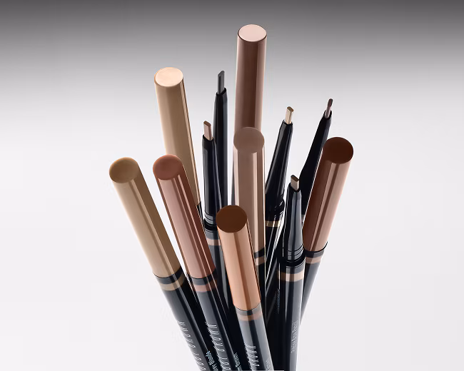 A collection of Bobbi Brown Long-Wear Cream Eyeshadow Sticks in various shades, showcasing their creamy texture and color range.